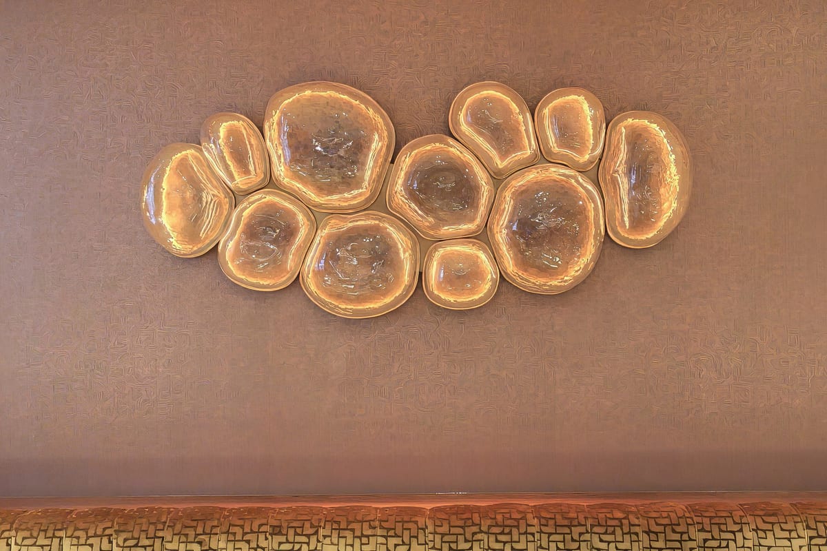 Illuminated agate discs set above a woven banquette in the dining room